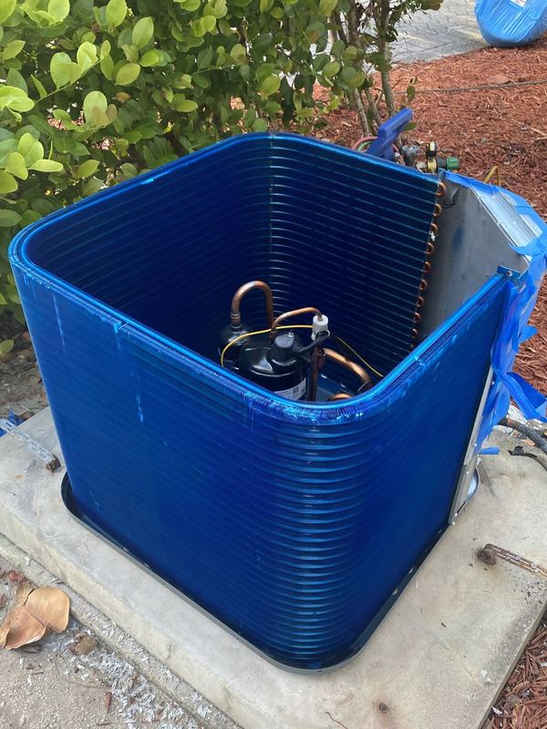 Coastal-proofing job: outdoor condenser opened up with its coil coated in blue protective anti-corrosion coating against salt air